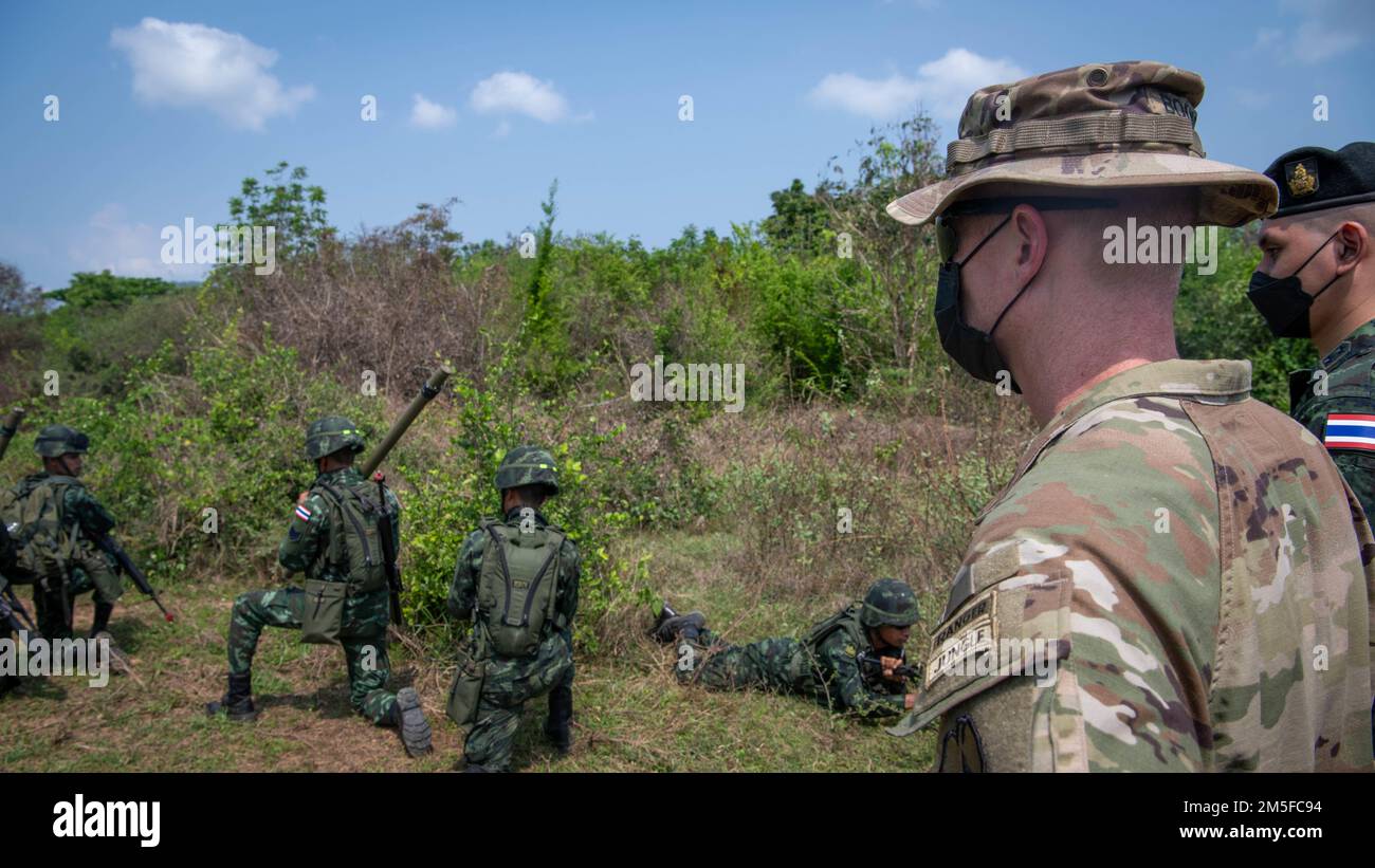 Josh Bookout, Comandante, 3rd squadra di combattimento della Brigata di Fanteria, 25th reggimento di Fanteria, e ufficiali dello staff del 15th reggimento di Fanteria, Royal Thai Army, guardano una squadra di siluro di Bangalore spostarsi verso un obiettivo di addestramento, il 11 marzo 2022, Fort Thanarat. La leadership ha visitato l'addestramento al fuoco vivo, ha pranzato con le truppe che hanno partecipato all'addestramento nella giungla e ha osservato l'addestramento degli esplosivi di Sapper. Foto Stock