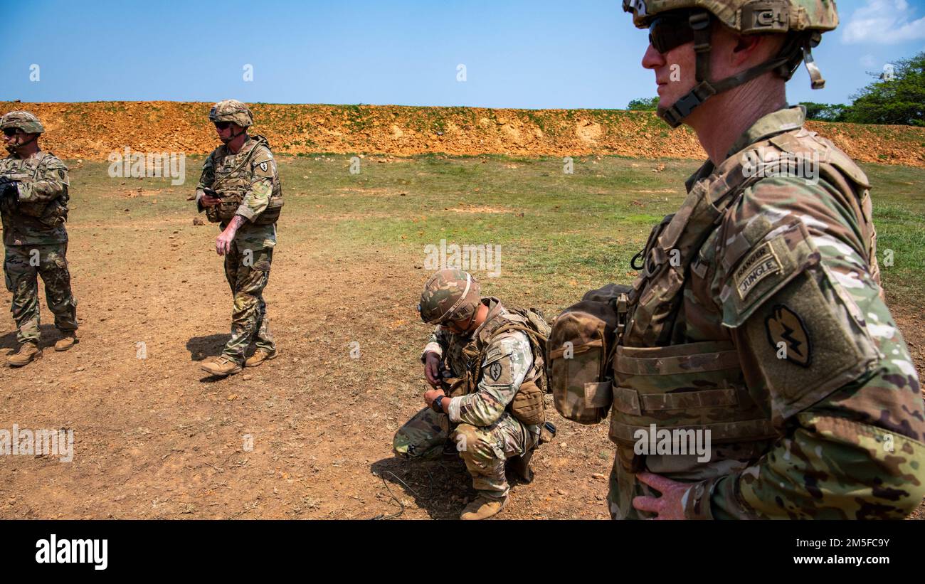 Josh Bookout, Comandante, 3rd squadra di combattimento della brigata di fanteria, 25th reggimento di fanteria, osserva i membri di Alpha Company, 29th Battaglione dell'ingegnere della brigata di fanteria, 3rd squadra di combattimento della brigata di fanteria, 25th reggimento di fanteria, prepara le cariche di cratering come parte dell'addestramento di Sapper. 11 marzo 2022, Fort Thanarat. La leadership ha visitato l'addestramento al fuoco vivo, ha pranzato con le truppe che hanno partecipato all'addestramento nella giungla e ha osservato l'addestramento degli esplosivi di Sapper. Foto Stock