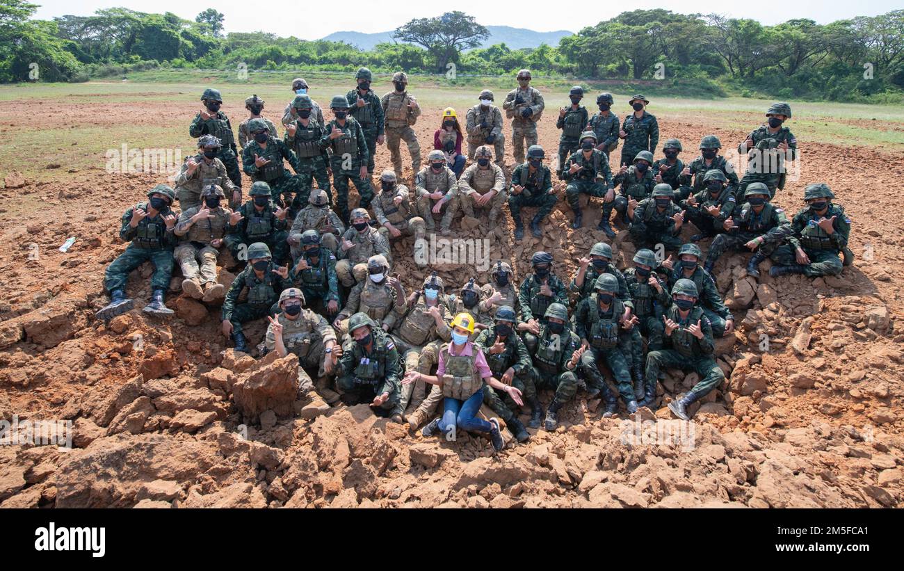 I membri di Alpha and Bravo Company, 29th Battaglione ingegnere Brigata, 3rd squadra di combattimento Brigata Fanteria, 25th reggimento Fanteria, i loro partner di addestramento dell'Esercito reale Tailandese e la squadra di interpreti si posano per una foto all'interno di un cratere realizzato come parte dell'addestramento di Sapper, 11 marzo 2022, Fort Thanarat. La leadership ha visitato l'addestramento al fuoco vivo, ha pranzato con le truppe che hanno partecipato all'addestramento nella giungla e ha osservato l'addestramento degli esplosivi di Sapper. Foto Stock