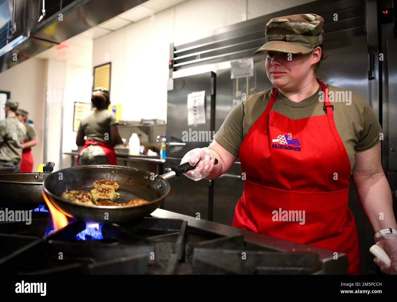 STATI UNITI Air Force Jennifer Benenhaley, 1st Special Operations Force Support Squadron Services Specialist, cucina il suo pasto sulla stufa durante il Chef of the Quarter Competition 11 marzo 2022 a Hurlburt Field, Florida. Ogni squadra di due persone, ha ricevuto 1,5 ore per creare un piatto stile brunch incorporando patate, uova, farina, banane e mele. Foto Stock