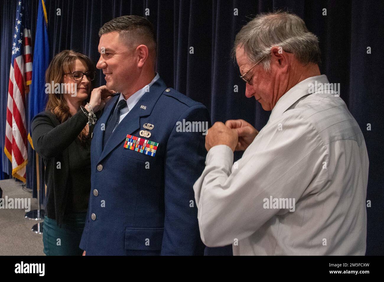 La moglie e il padre di Robert Kolvet segnano il suo nuovo grado di tenente colonnello sulla sua uniforme durante la cerimonia di promozione di Kolvet Venerdì. 11 marzo 2022 presso la base della Guardia Nazionale dell'aria del Nevada a Reno, Never. Foto Stock