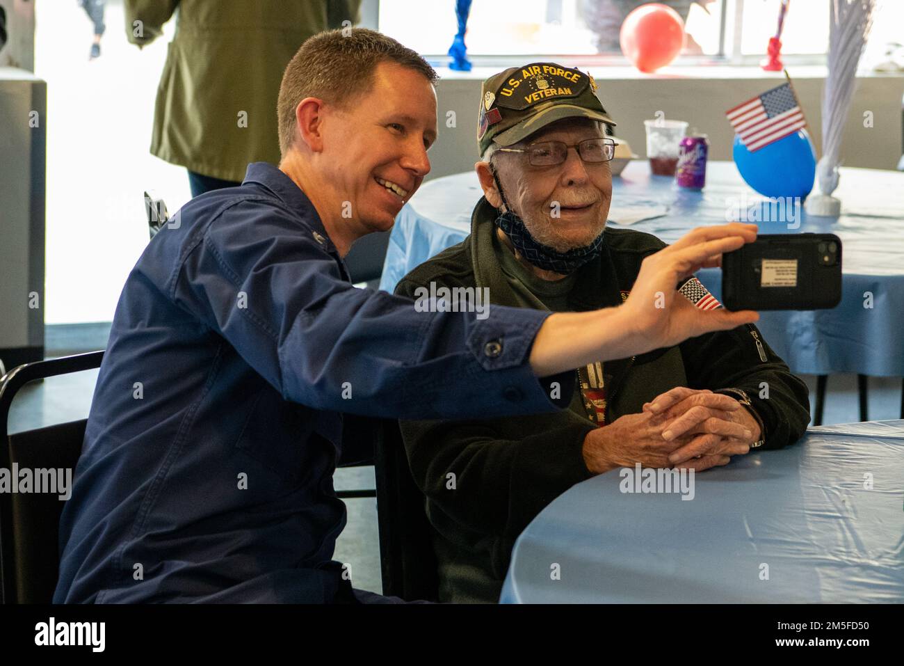 Il capitano Jason Smith, comandante del settore della Guardia Costiera Houston-Galveston, scatta una foto con un veterano durante un evento volontario della Campagna Federale combinata nella casa di un veterano di Houston, Texas, il 11 marzo 2022. I membri hanno cucinato e tagliato il pranzo ai residenti locali accanto agli Stati Uniti L'immigrazione e l'applicazione delle dogane e il Michael E. DeBakey Veterans Affairs Medical Center, come parte di un evento volontario in collaborazione con gli Stati Uniti Vets Houston e la Veteran Initiative. Foto Stock