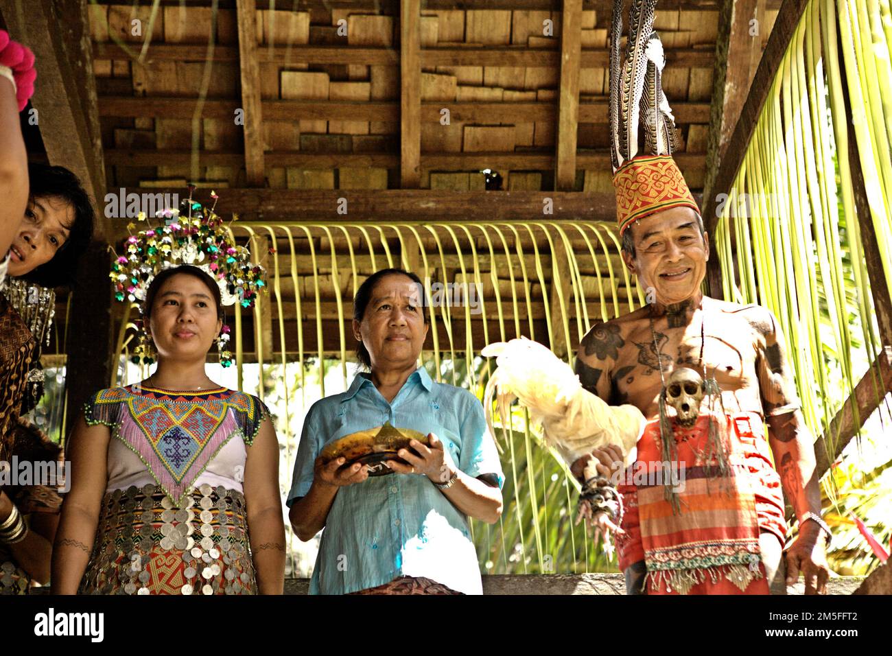 Ramping, un anziano, sta portando un pollo bianco, un simbolo di sincerità, in quanto è in piedi per accogliere gli ospiti durante un evento presso la comunità IBAN di Dayak che è noto per la consapevolezza ambientale e la gestione sostenibile delle foreste, in questa foto scattata a Sungai Utik, Kapuas Hulu, Kalimantan occidentale, Indonesia. Nonostante il 5% della popolazione mondiale, le popolazioni indigene proteggono circa il 80% della biodiversità globale, secondo un team di ricercatori nel loro rapporto pubblicato per la prima volta sul colloquio del 14 dicembre 2022. Foto Stock