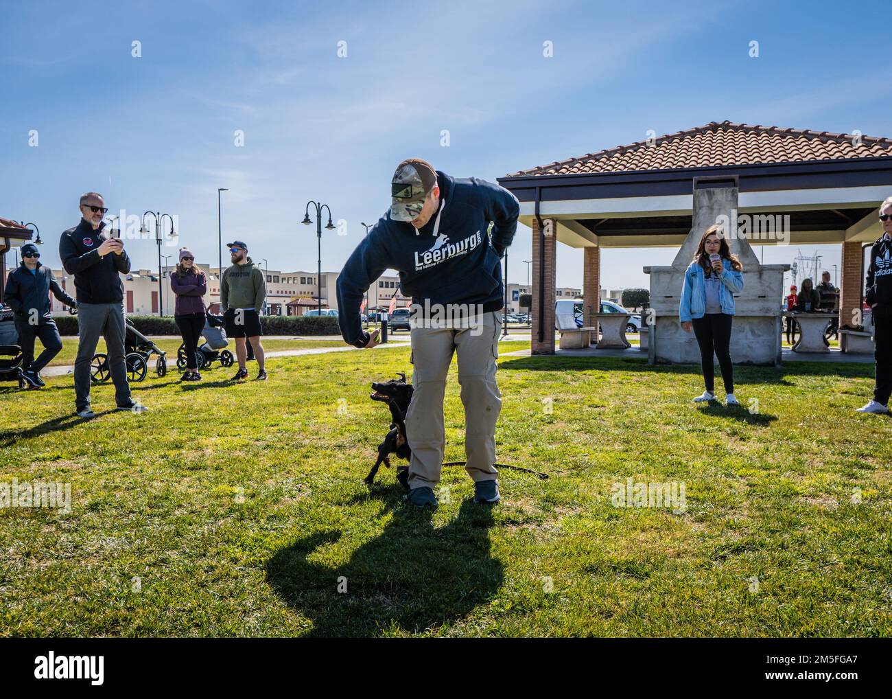 STATI UNITI Scott Chilko, Capo del Master-at-Arms della Marina, circoli una palla per Military Working Dog (MWD) Boy durante una dimostrazione di abilità a bordo Naval Support Activity (NSA) Napoli Support Site a Gricignano, Italia, 12 marzo 2022. La dimostrazione di abilità fa parte della celebrazione della Giornata dei Veterani K-9 della NSA Naples MWD Security Team, organizzata per commemorare il servizio e i sacrifici dei cani militari e da lavoro americani e per educare i membri della comunità NSA Naples al programma MWD. La NSA Naples è una base operativa a terra che consente alle forze nazionali statunitensi, alleate e partner di essere dove sono necessarie, Foto Stock