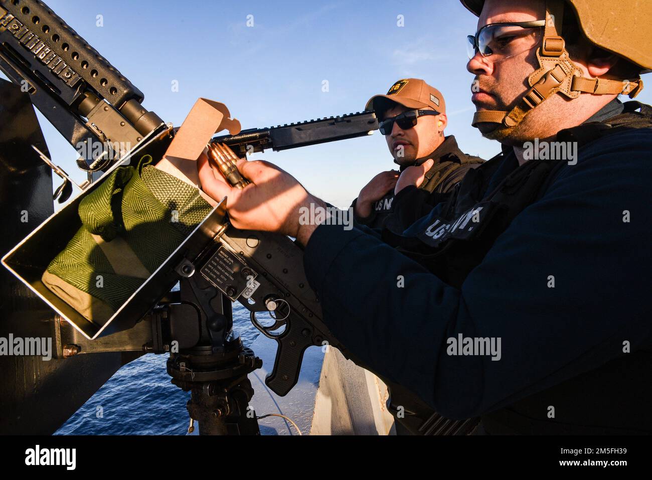 OCEANO PACIFICO (12 marzo 2022) Gunner’s Mate 1st Class Casey Acosta, da Oak Hills, California, davanti, carica un fucile montato M240 come Gunner’s Mate 3rd Class Michael Nava, da Chicago, osserva durante un esercizio di fuoco a bordo di una nave portuale anfibia da trasporto USS John P. Murtha (LPD 26), marzo 12. John P. Murtha sta conducendo operazioni di routine nella U.S. 3rd Fleet. Foto Stock