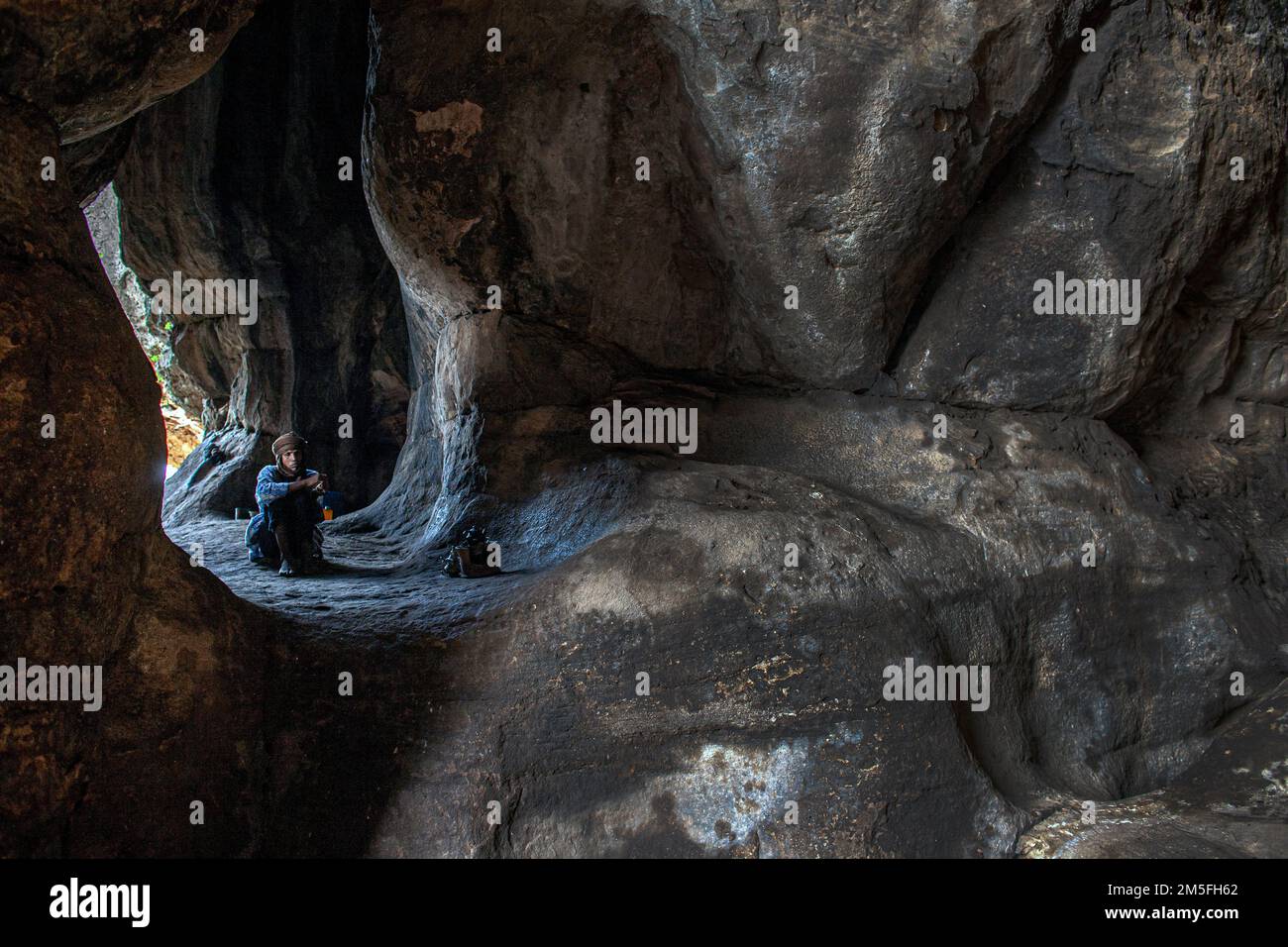 Marabout seduto in grotta . Le grotte di missirikoro , Mali , Africa occidentale. Foto Stock