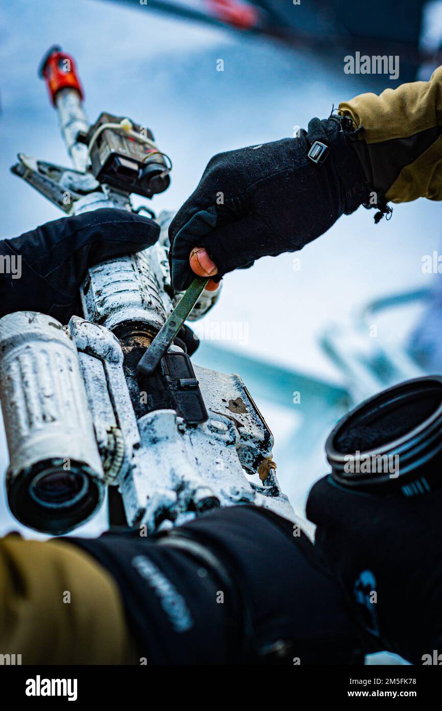 Soldati del battaglione del 3rd, Royal 22e Régiment Canadian Army applica lubrificante grafite per mantenere i fucili funzionanti a basse temperature mentre si preparano a condurre una missione di ricognizione nell'area di addestramento di Fort Greely AK con i membri delle forze speciali degli Stati Uniti durante il Joint Pacific multinazionale Readiness Center 22-02 il 13 marzo 2022. JPMRC 22-02 è la prima rotazione regionale del Centro di addestramento al combattimento in Alaska. Si concentra su LSCO (Large Scale Combat Operations) ed è un evento di addestramento per climi freddi che include un esercizio di addestramento all'ipofisi (STX) e un esercizio di fuoco vivo (LFX) nel 2QF Foto Stock