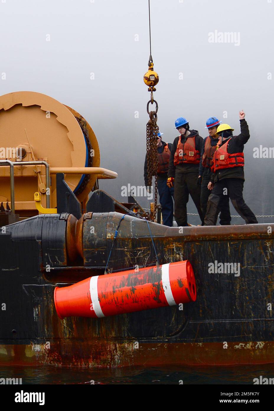 STATI UNITI Gli operatori del settore Coast Guardsmen utilizzano una gru a braccio per sollevare un supporto di addestramento inerte situato negli Stati Uniti Navy Explosive Ordnance Disposal Mobile Unit (EODMU) 1 a bordo della gara di boa costiera di classe Keeper USCGC Anthony Petit (WLM 558) nel canale di Gastineau vicino a Juneau, Alaska, 13 marzo 2022, durante l'esercizio ARCTICE EDGE 2022 (AE22). AE22 è un esercizio difensivo per gli Stati Uniti Northern Command e forze armate canadesi per dimostrare ed esercitare la nostra capacità di dispiegarsi e operare rapidamente nell'Artico. Foto Stock