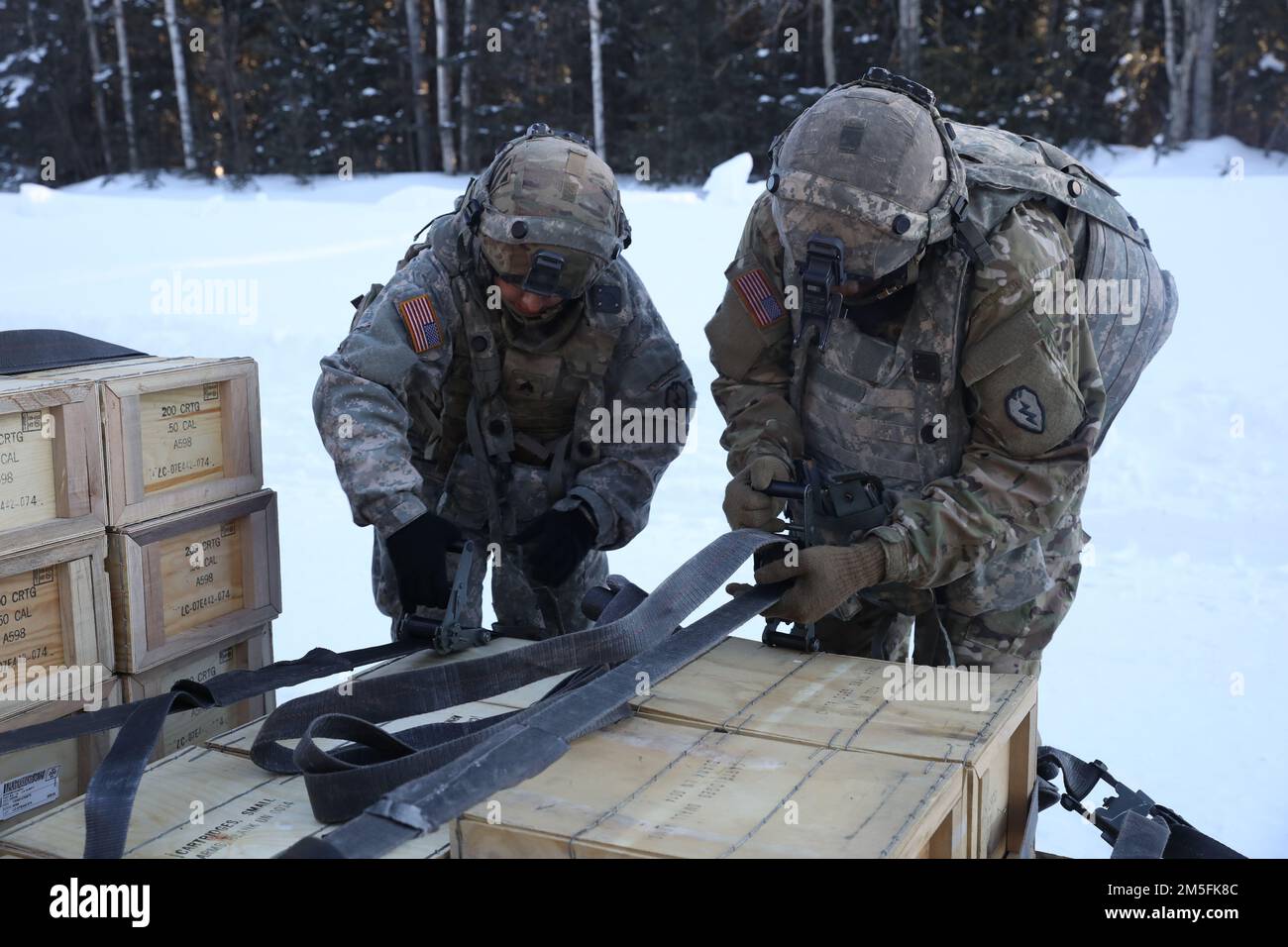 STATI UNITI Erin Schoenfeld e gli Stati Uniti Makhi Spencer di 1st Stryker Brigade Combat Team, 25th° divisione fanteria, assegnato agli Stati Uniti Esercito Alaska, scaricare un camion di munizioni per un convoglio a Fort Greely, AK il 13 marzo 2022. Il Joint Pacific Multinational Readiness Center 22-02 è il primo centro regionale di addestramento al combattimento (HS-CTC) a rotazione in Alaska, che si concentra sulle operazioni di combattimento su larga scala (LSCO) ed è un evento di addestramento alle basse temperature che include un esercizio di addestramento situazionale (STX) e un esercizio di fuoco vivo (LFX). Foto Stock