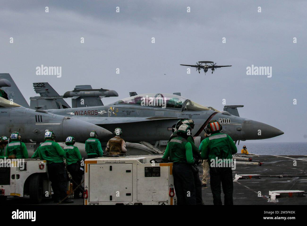 MARE DELLE FILIPPINE (14 marzo 2022) i marinai osservano le operazioni di volo sul ponte di volo della portaerei di classe Nimitz USS Abraham Lincoln (CVN 72). Abraham Lincoln Strike Group è in fase di implementazione pianificata nell'area delle operazioni della flotta 7th degli Stati Uniti per migliorare l'interoperabilità attraverso alleanze e partnership e al tempo stesso fungere da forza di risposta pronta a sostegno di una regione indomPacifico libera e aperta. Foto Stock