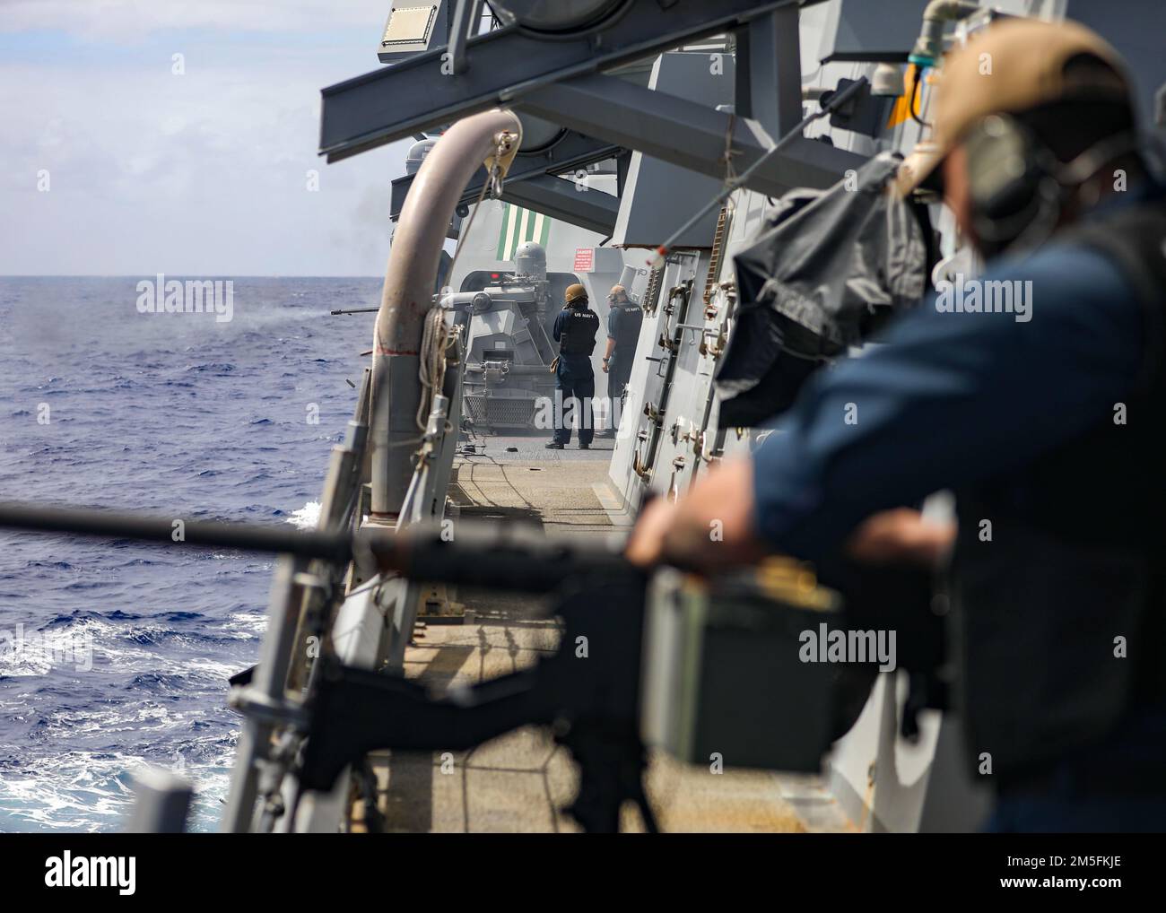 MARE DELLE FILIPPINE (12 marzo 2022) il cacciatorpediniere missilistico guidato di classe Arleigh Burke USS Higgins (DDG 76) esegue un'esercitazione di sparo dal vivo con una mitragliatrice Bushmaster MK da 38 25 mm. Higgins è assegnato al Comandante, Task Force (CTF) 71/Destroyer Squadron (DESRON) 15, il più grande DESRON della Marina e la principale forza di superficie della flotta statunitense 7th. Foto Stock