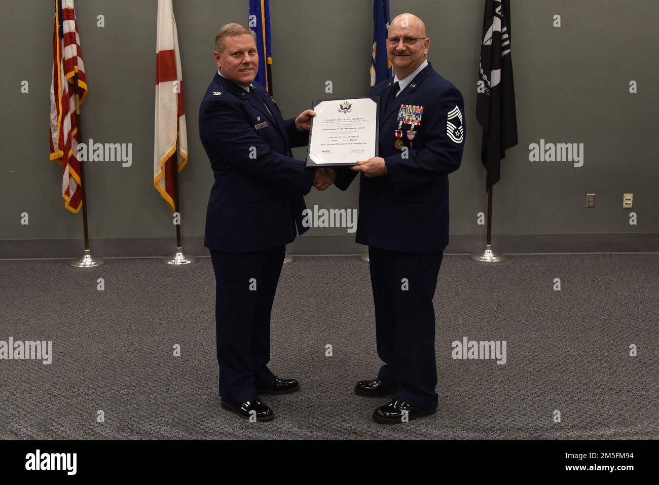 I membri dell'Ala per il rifornimento aereo 117th partecipano alla cerimonia di ritiro del Capo Maestro Sgt. John Isbell alla Sumpter Smith Joint National Guard base, Alabama, 13 marzo 2022. Isbell si ritirò dopo più di 35 anni nella Guardia Nazionale aerea. Foto Stock