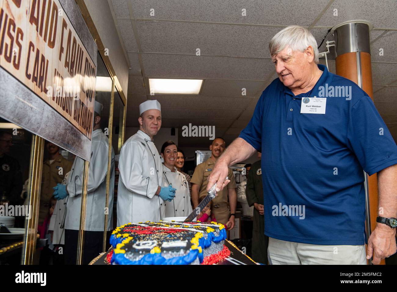 220313-N-SS900-1169 SAN DIEGO (13 marzo 2022) il proprietario del piano Curt Webber, nativo di Peoria, Ariz., taglia una torta durante una cerimonia che celebra il 40th° anniversario della messa in servizio della portaerei di classe Nimitz USS Carl Vinson (CVN 70), 13 marzo 2022. Vinson è attualmente pierside nel suo homeport di San Diego. Foto Stock
