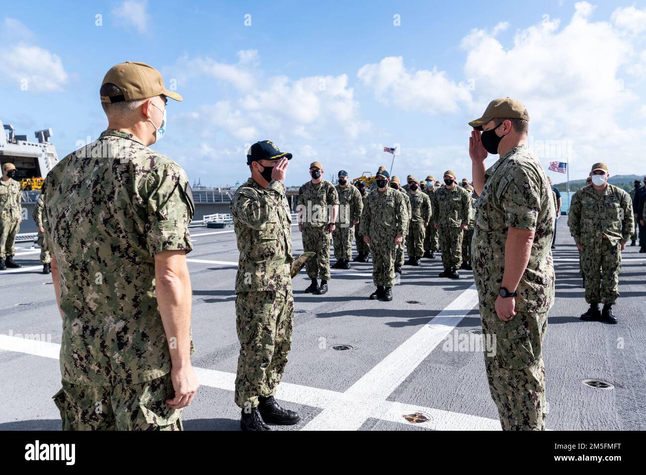 220315-N-LI768-1006 APRA HARBOR, Guam (15 marzo 2022) – CMdR. Brandon Cornes, comandante della USS Tulsa (LCS 16) (Blue), al centro, saluta CMdR. Travis Dvorak, comandante di Tulsa (oro), durante una cerimonia di scambio di comando sul ponte di volo della nave litoranea da combattimento variante dell'Indipendenza. L'equipaggio di Tulsa Blue ha sollevato Tulsa Gold dopo cinque mesi di attività nell'area delle 7th Fleet degli Stati Uniti. Tulsa, parte di Destroyer Squadron (DESRON) 7, è su una distribuzione rotazionale, che opera negli Stati Uniti 7th Fleet AOR per migliorare l'interoperabilità con i partner e servire come pronto-r Foto Stock