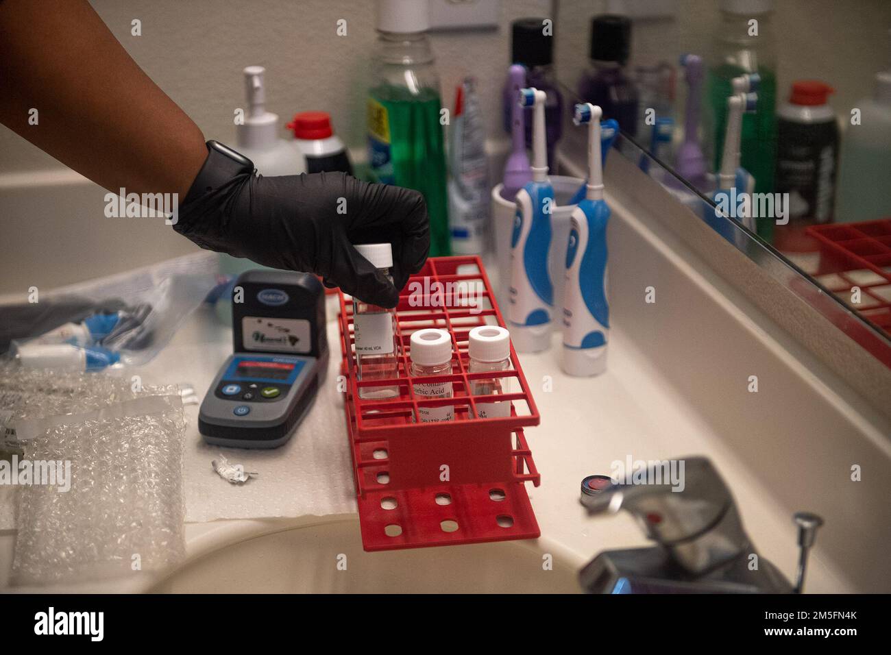 PEARL CITY, Hawaii (14 marzo 2022) - Un appaltatore del comando Naval Facilities Engineering Systems prende campioni d'acqua a Pearl City Peninsula come parte di un piano approvato interagenzia per il monitoraggio a lungo termine dell'acqua potabile. Gli Stati Uniti Navy sta lavorando a stretto contatto con il Dipartimento della Salute delle Hawaii, Stati Uniti Environmental Protection Agency e gli Stati Uniti Esercito per ripristinare l'acqua potabile sicura alle comunità abitative di Joint base Pearl Harbor-Hickam attraverso il campionamento e il lavaggio, e il recupero del pozzo di Red Hill. Per informazioni dettagliate, visitare il sito Web www.navy.mil/jointbasewater. Foto Stock