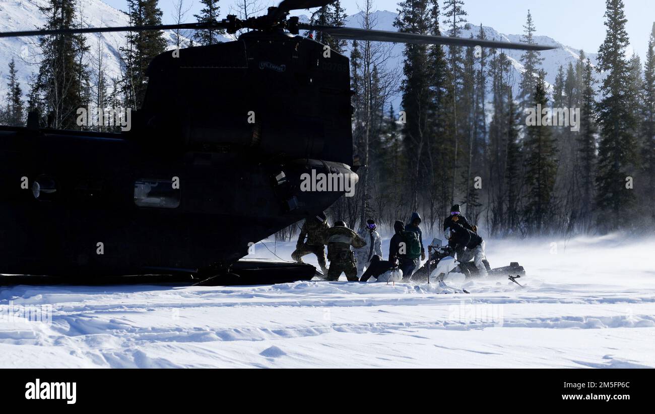 Green Berets with 10th Special Forces Group (Airborne) carica una motoslitta in un elicottero MH-47 Chinook con 160th Special Operations Aviation Regiment (Airborne) durante l'esercizio ARCTIC EDGE 2022 a Wiseman, Alaska, 14 marzo 2022. AE22 è un esercizio biennale multi-servizio progettato per fornire una formazione realistica ed efficace ai partecipanti che utilizzano i principali centri di formazione disponibili in tutta l'Alaska dal 28 febbraio al 17 marzo. Foto Stock