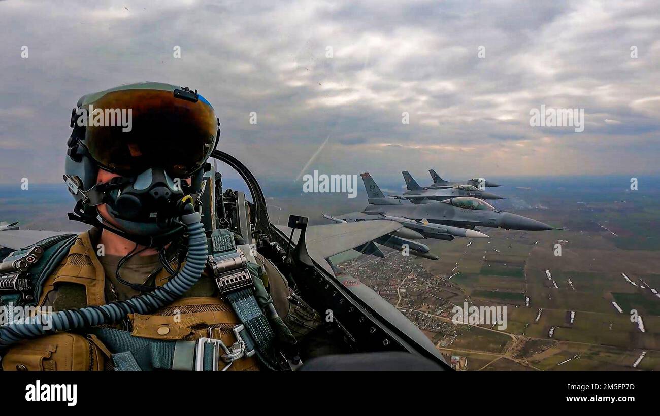 Due Stati Uniti Air Force F-16 Fighting Falcon Aircraft assegnato al 480th Expeditionary Fighter Squadron presso la base aerea di Spangdahlem, Germania, volano accanto a due F-16s rumeni sulla Romania, 14 marzo 2022. Gli aerei si addestrano regolarmente con i partner e gli alleati della NATO per garantire la sicurezza e la stabilità all'interno del teatro europeo. Foto Stock