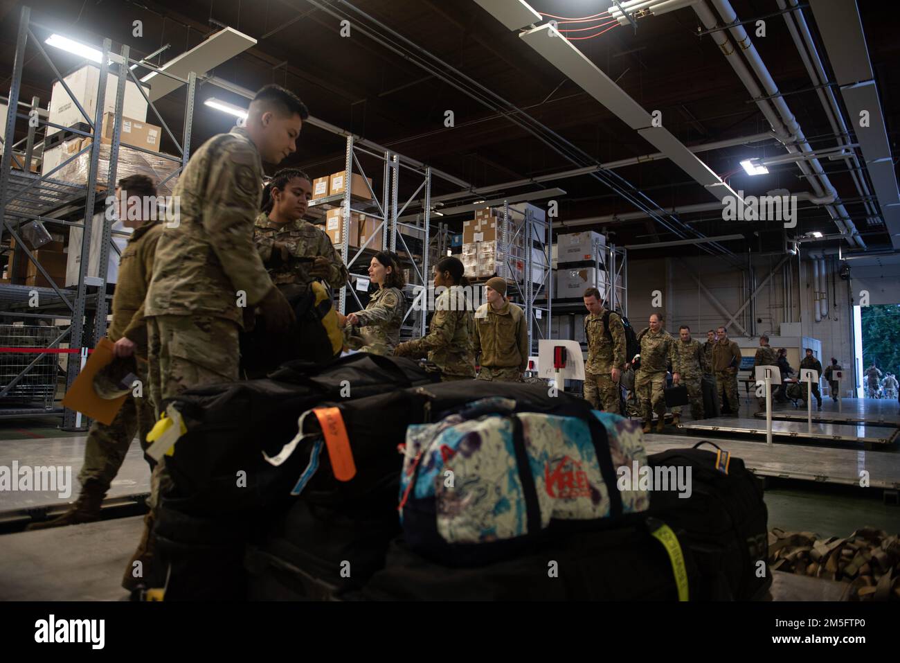 STATI UNITI Air Force Airmen con il 62nd Aerial Port Squadron organizzano le borse personali dei dispiegatori in preparazione per l'esercizio Rainier War 22A presso la Joint base Lewis-McChord, Washington, 15 marzo 2022. Rainier War 22A esercitò e valutò la capacità dell'ala di impiegare la forza e la sua capacità di eseguire durante le operazioni di guerra e/o di contingenza in un ambiente ad alta intensità, conteso in tempo di guerra, degradato e limitato dal punto di vista operativo, sostenendo le operazioni di contingenza contro un avversario vicino-pari. Foto Stock
