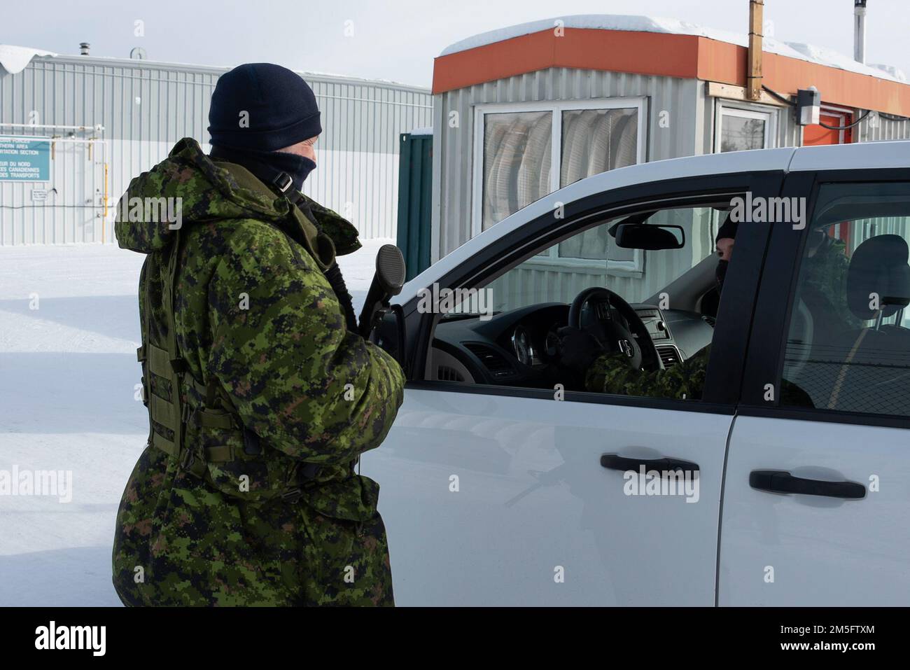 Il personale della WASF (Wing Auxiliary Security Force) verifica l'identificazione e l'autorizzazione di sicurezza del membro prima di consentire l'ingresso nella posizione operativa di Yellowknife, territori del nord-ovest 15 marzo 2022. NORAD Operation NOBLE DEFENDER 22-2 è un'operazione di difesa aerea che si svolge dal 14 al 17 marzo 2022 e che coinvolge una serie di aerei militari della Royal Canadian Air Force (RCAF) e dell'aviazione militare degli Stati Uniti. Il personale e gli aerei sono basati fuori dalla stazione di allarme delle forze canadesi, Nunavut; Whitehorse, Yukon; Yellowknife, Northwest Territories; e 5 Wing Goose Bay, Terranova Foto Stock