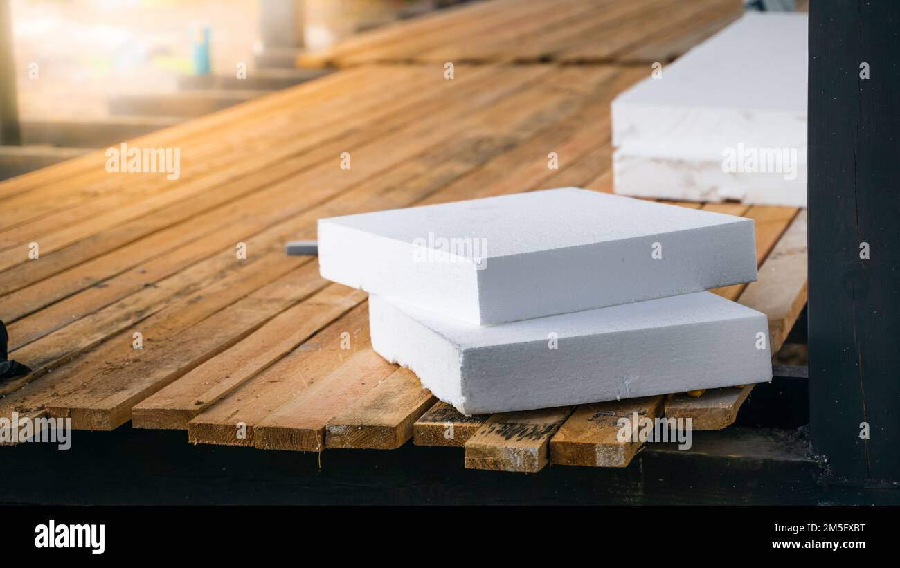 Uno spesso styrofoam bianco si trova in un primo piano del cantiere. Isolamento della casa durante la costruzione con polistirolo espanso Foto Stock