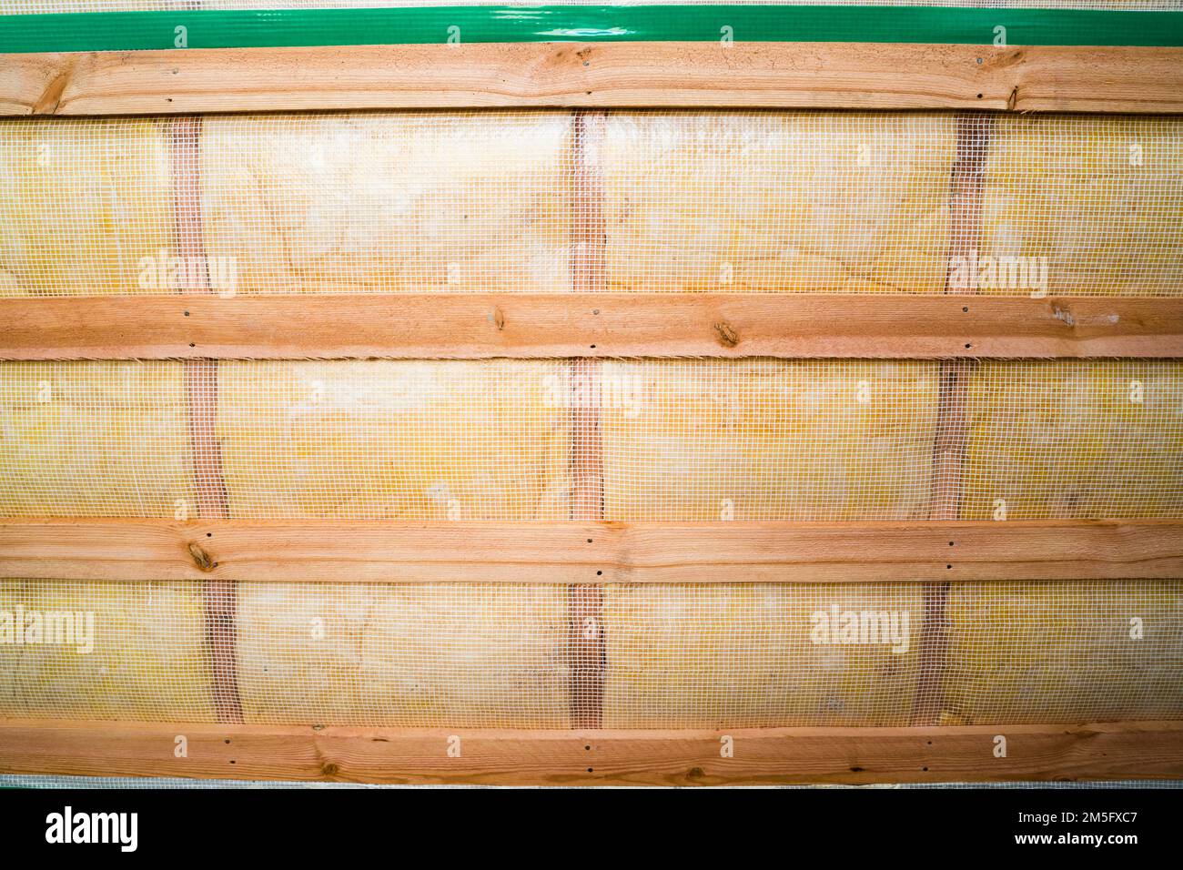 La lana di vetro è posta tra le travi del tetto e chiusa con una barriera al vapore, vista dal basso Foto Stock