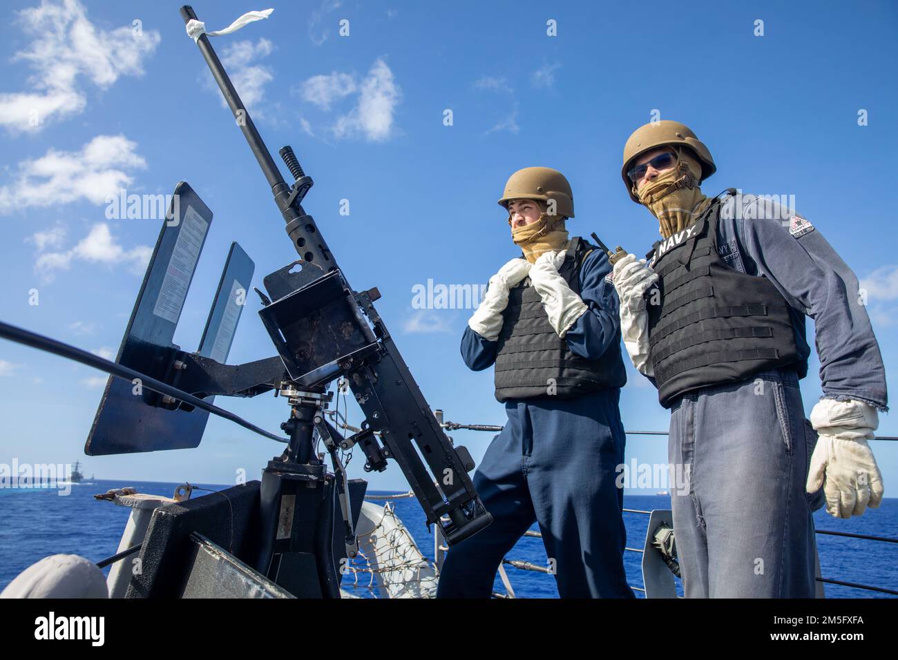 220315-N-XG173-1116 MARE DELLE FILIPPINE (15 marzo 2022) Interior Communications Electrician 2nd Class Dylan Gardner, di Huntsville, al, LEFT, e Retail Services Specialist Parker Jahnigen, di Osgood, IN, entrambi assegnati al cacciatorpediniere missilistico guidato della classe Arleigh-Burke USS Barry (DDG 52) man un mitragliatore di calibro M2 .50 durante un allenamento. USS Barry è assegnato a Destroyer Squadron (DESRON) 15 ed è in corso il supporto di un libero e aperto Indo-Pacific. CTF 71/DESRON 15 è la più grande DESRON della Marina e la principale forza di superficie della flotta statunitense 7th. Foto Stock