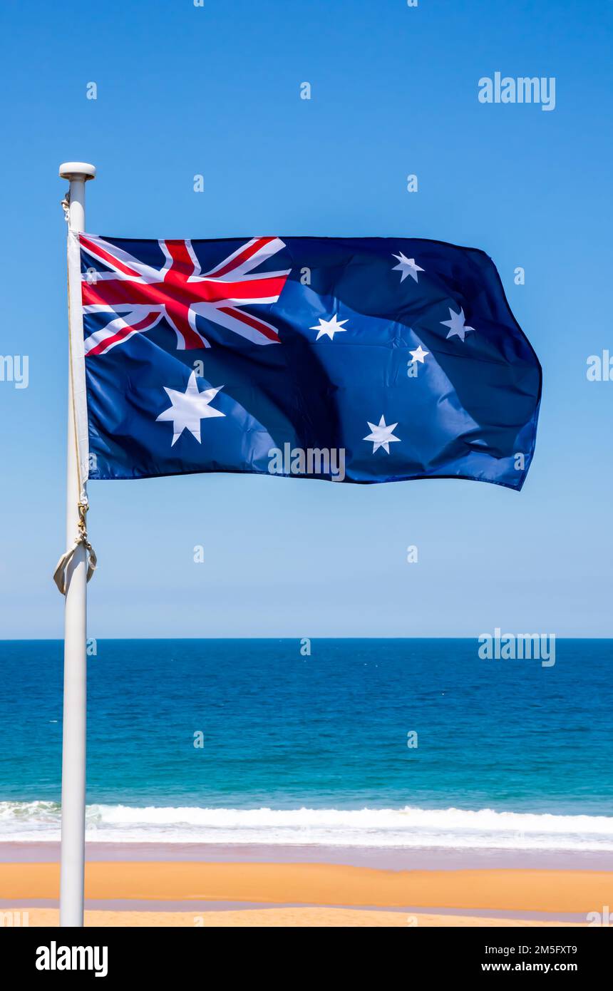 Bandiera australiana contro un cielo blu, oceano e spiaggia Foto Stock