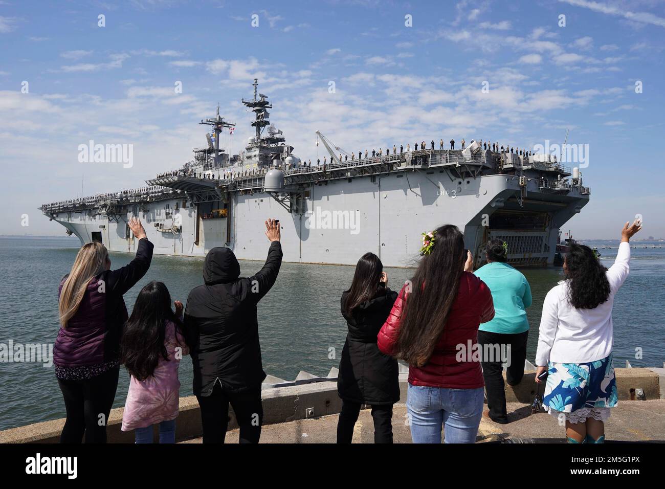 NORFOLK, Virginia (16 marzo 2022) - famiglie di membri dell'equipaggio della nave d'assalto anfibio di classe Wasp USS Kearsarge (LHD 3) si muovono mentre la nave parte dalla stazione navale di Norfolk, 16 marzo 2022. Kearsarge Amphhibious Readiness Group (ARG) con imbarcato 22nd Marine Expeditionary Unit (MEU) dispiegato dalla Naval Station Norfolk e Camp Lejeune, North Carolina, per un dispiegamento regolarmente programmato. Foto Stock