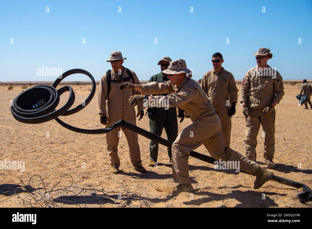 STATI UNITI Marines assegnato a Aviation Ground Support, Marine Aviation Weapons and Tactics Squadron One (MAWTS-1) dispiega una manichetta carburante durante un'applicazione pratica del punto di armamento e rifornimento (FARP), durante il corso Weapons and Tactics Instructor (WTI) 2-22, presso Auxiliary Airfield II, vicino a Yuma, Arizona, 16 marzo 2022. WTI è un evento di formazione di sette settimane organizzato da MAWTS-1, che fornisce formazione tattica avanzata di standardizzazione e certificazione delle qualifiche di istruttore di unità per supportare la formazione e la preparazione dell'aviazione marina e per assistere nello sviluppo e nell'impiego di armi e tattiche per l'aviazione. Foto Stock