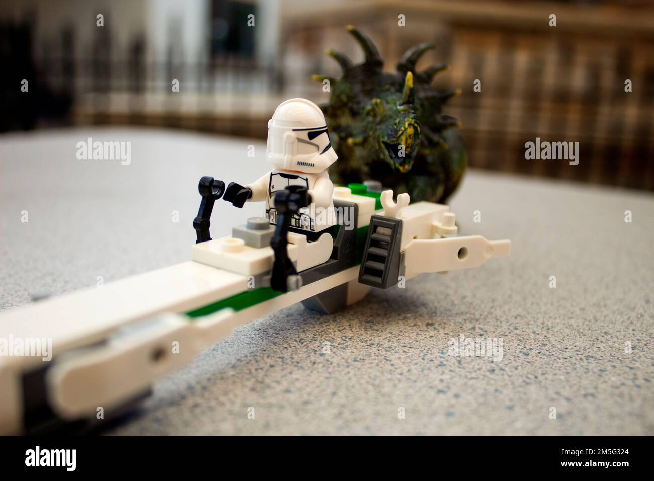 Il dinosauro giocattolo si avvicina a Lego Star Wars Storm Trooper Foto Stock