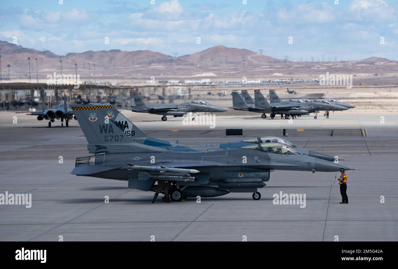 Due F-16 Fighting Falcon della squadra di Aggressor 64th, della base dell'aeronautica di Nellis, Nevada, e sei F-15Es della base dell'aeronautica di Mountain Home, Idaho, aspettano di decollare per la missione Red Flag-Nellis 22-2 alla base dell'aeronautica di Nellis, Nevada, 16 marzo 2022. Gli esercizi a bandiera rossa forniscono agli equipaggi l'esperienza di molteplici e intense operazioni di combattimento aereo nella sicurezza di un ambiente di allenamento. Foto Stock