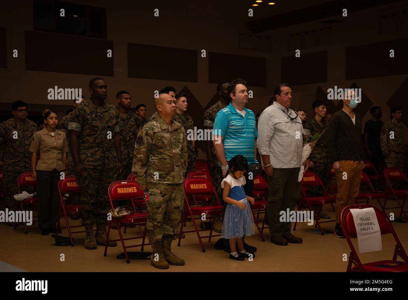 I partecipanti si sono impegnati per la promessa di Allegiance durante una cerimonia di naturalizzazione presso il centro comunitario, Camp Foster, Okinawa, Giappone, il 16 marzo, 2022. Durante le cerimonie di naturalizzazione, i familiari e gli amici testimoniano la parte finale del processo d'oltremare dei candidati che diventano cittadini degli Stati Uniti. Foto Stock