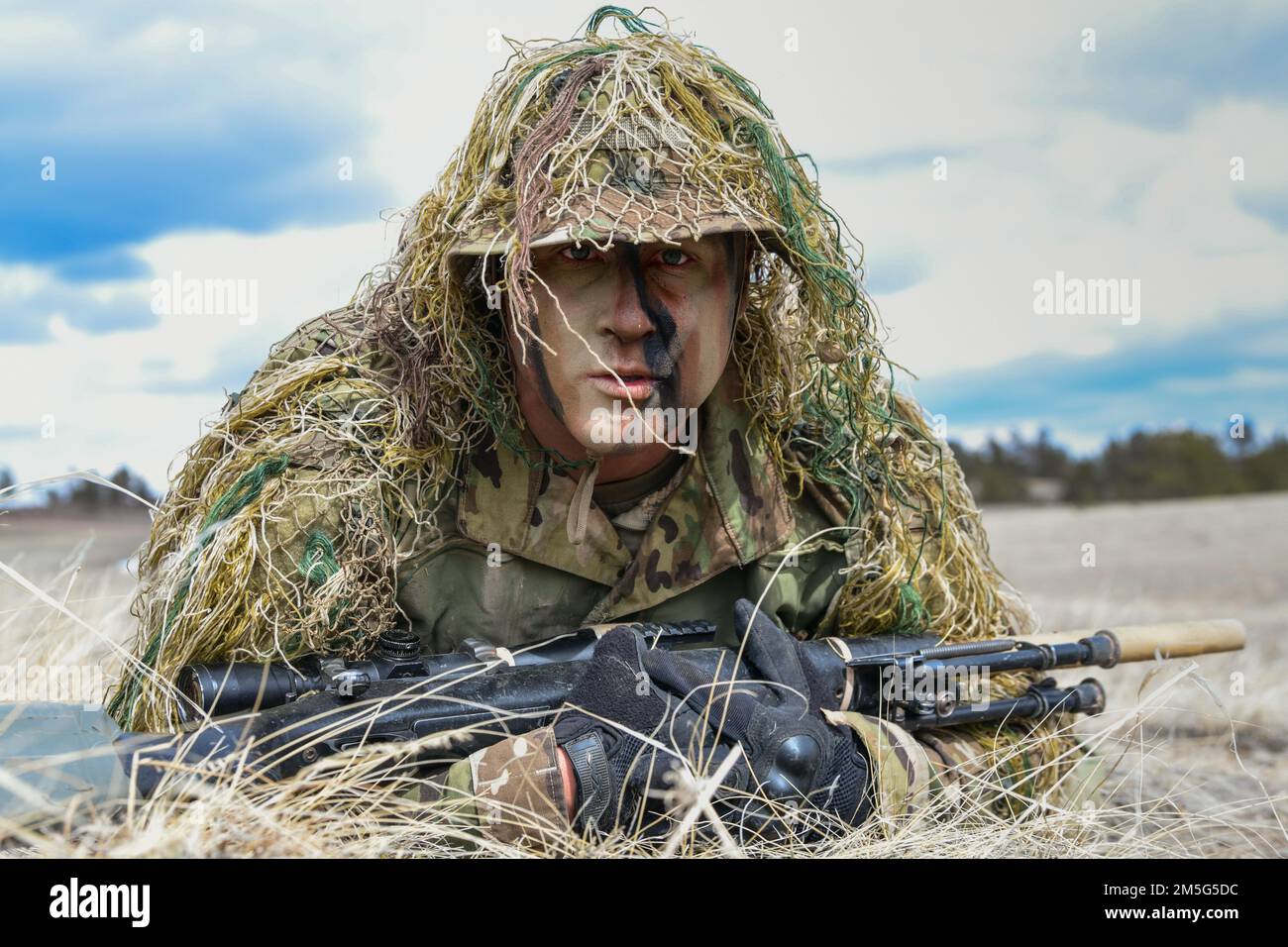 Lo staff Sgt. Aaron Lee, 341 Missile Security Operations Squadron, Malmstrom Air Force base, Montana, dimostra un'elevata crescita durante il corso Nuclear Advanced Designated Marksman 16 marzo 2022 a Camp Guernsey, Wyoming. I cecchini hanno diversi tipi di strisci che li aiutano a rimanere nascosti in qualsiasi ambiente. Foto Stock