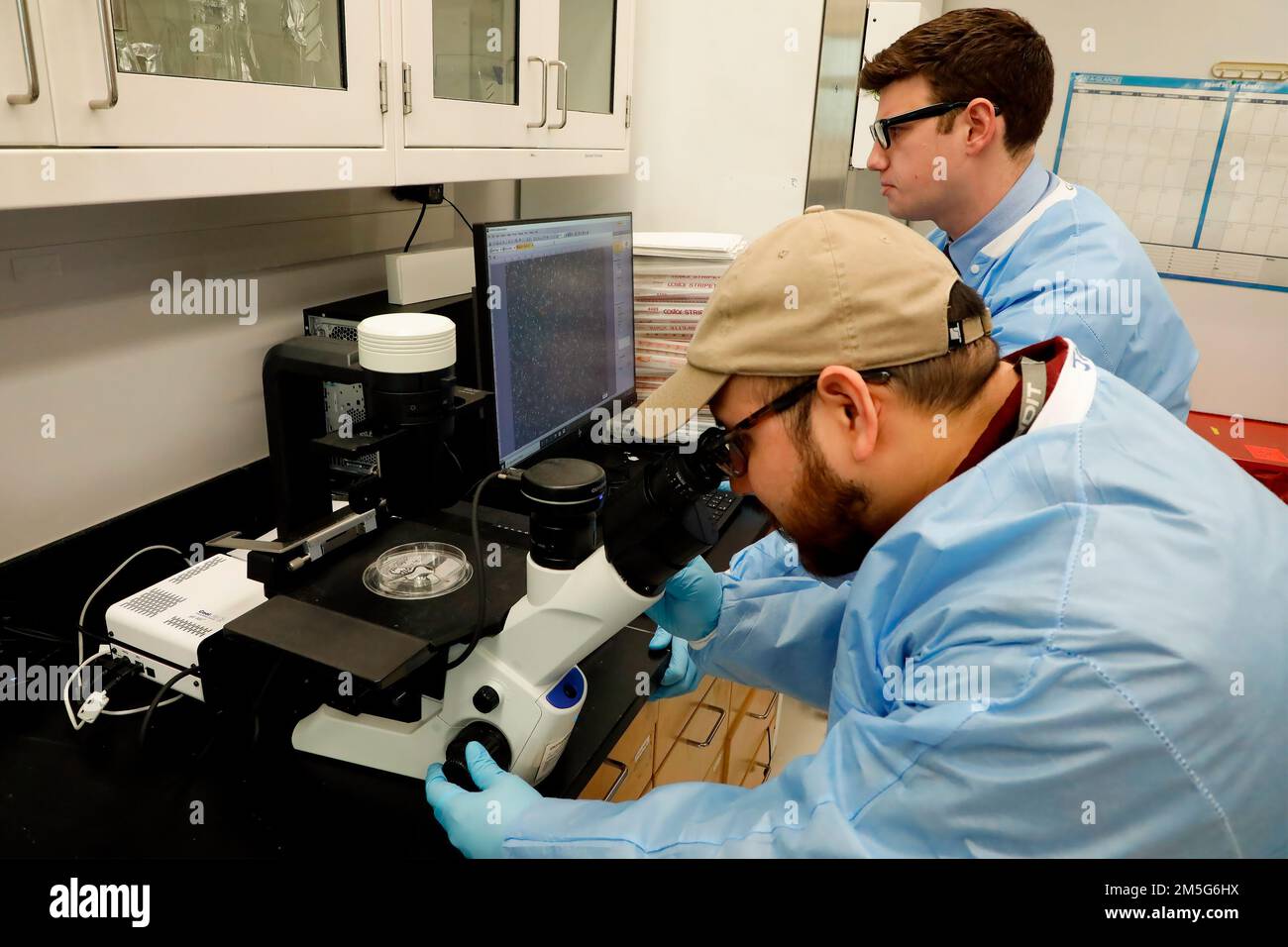 SILVER SPRING, Md (16 marzo 2022) – Jason Pilligua e Christian McCauley, entrambi gli assistenti di ricerca del Naval Medical Research Center (NMRC) esaminano i batteri utilizzando un microscopio a fluorescenza invertita nel laboratorio della Combat Wedes Database Division. Parte del Dipartimento delle infezioni di NMRC, la Combat Wound Database Division sviluppa e valuta nuovi trattamenti per combattere le infezioni cutanee e dei tessuti molli associate a organismi multi-resistenti alle lesioni. Foto Stock