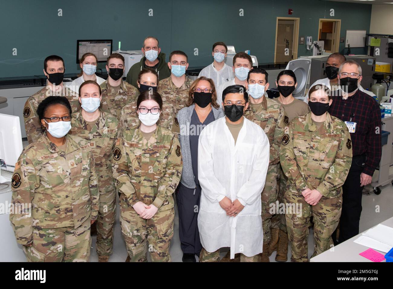 Il team del laboratorio del Gruppo medico 673d si ferma per una foto alla Joint base Elmendorf-Richardson, Alaska, 16 marzo 2022. Il team ha notevolmente aumentato le proprie capacità di test per il virus COVID-19 e altre infezioni respiratorie quando ha acquisito due analizzatori ad alta capacità, uno nel novembre 2021 e l'altro nel gennaio 2022. Uno degli analizzatori è in grado di testare 1.152 campioni al giorno ed è l'unico analizzatore di questa capacità del Dipartimento della Difesa. Foto Stock