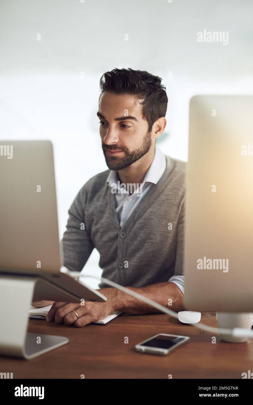 Rimane in cima al suo lavoro, un uomo d'affari che lavora nel suo ufficio. Foto Stock