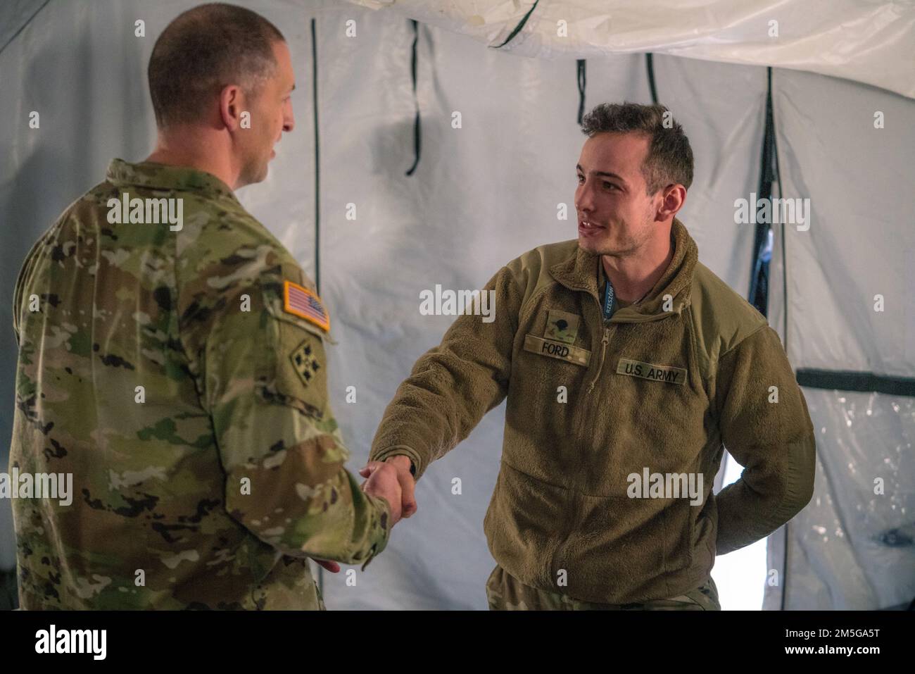 Giancarlo Macri, del 10th° Army Air and Missile Defense Command, si congratula con SPC. Ford, un difensore dell'aria assegnato al 5th° Battaglione, 7th° Reggimento dell'artiglieria di difesa dell'aria, durante una visita in Polonia il 16 marzo 2022. Foto Stock