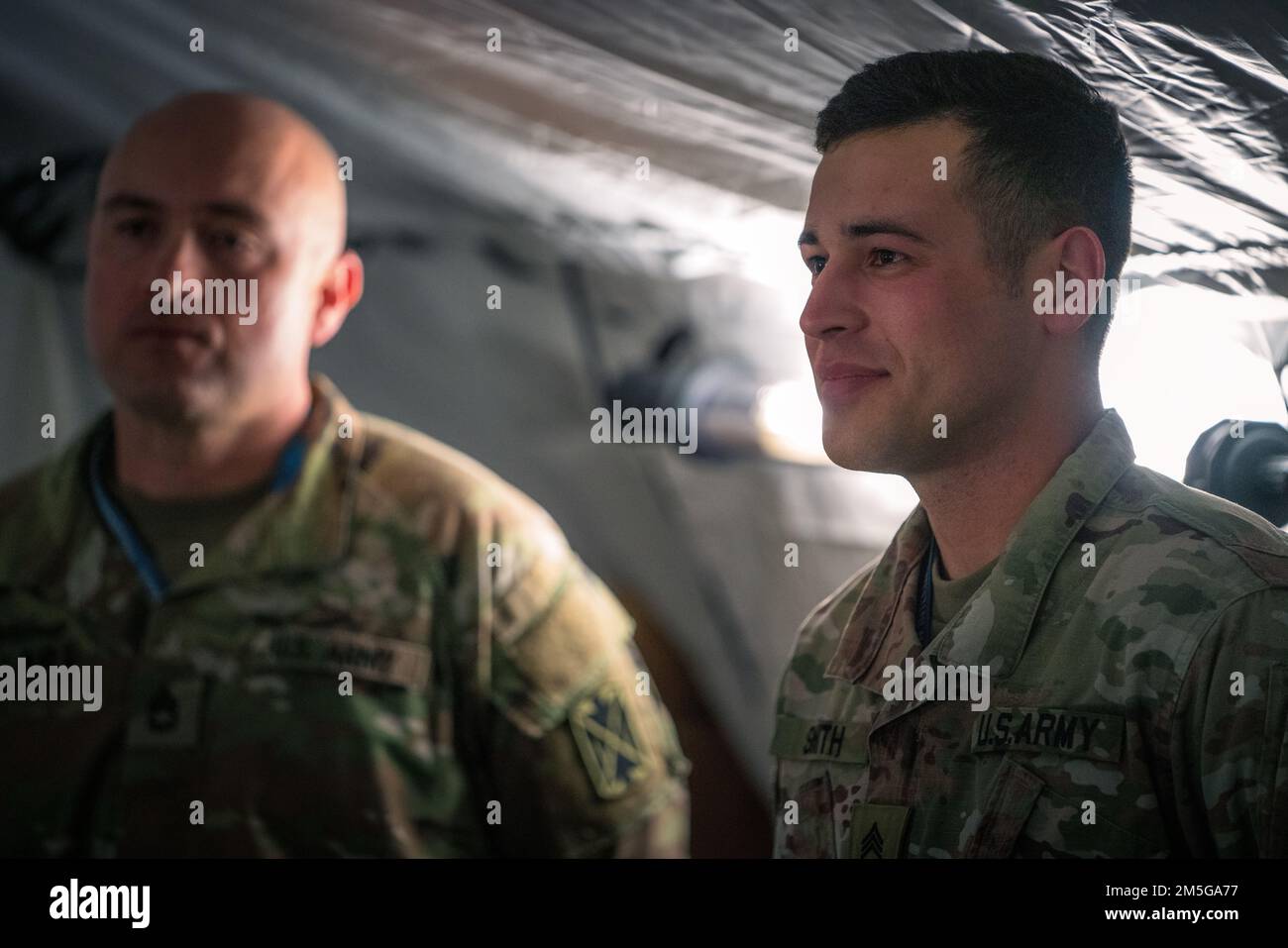 Lo staff Brendan Smith, un difensore dell'aria assegnato al battaglione del 5th, 7th reggimento dell'artiglieria di difesa aerea, riceve la moneta del comandante per l'eccellenza dal generale Greg Brady, comandante generale del comando della difesa aerea e missilistica dell'esercito del 10th durante una visita in Polonia il 16 marzo 2022. Foto Stock