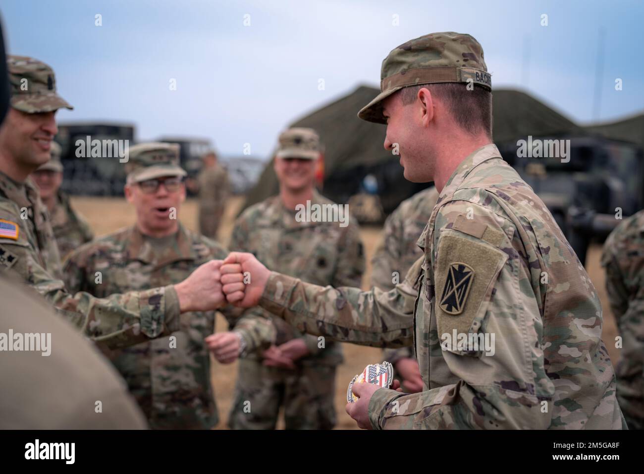 Il comando del maggiore Giancarlo Macri dell'Armata 10th Air and Missile Defense Command, si congratula con SPC. Samuel Backes, un difensore dell'aria assegnato al 5th Battaglione, 7th Air Defense Artillery Regiment, durante una visita in Polonia il 16 marzo 2022. Foto Stock