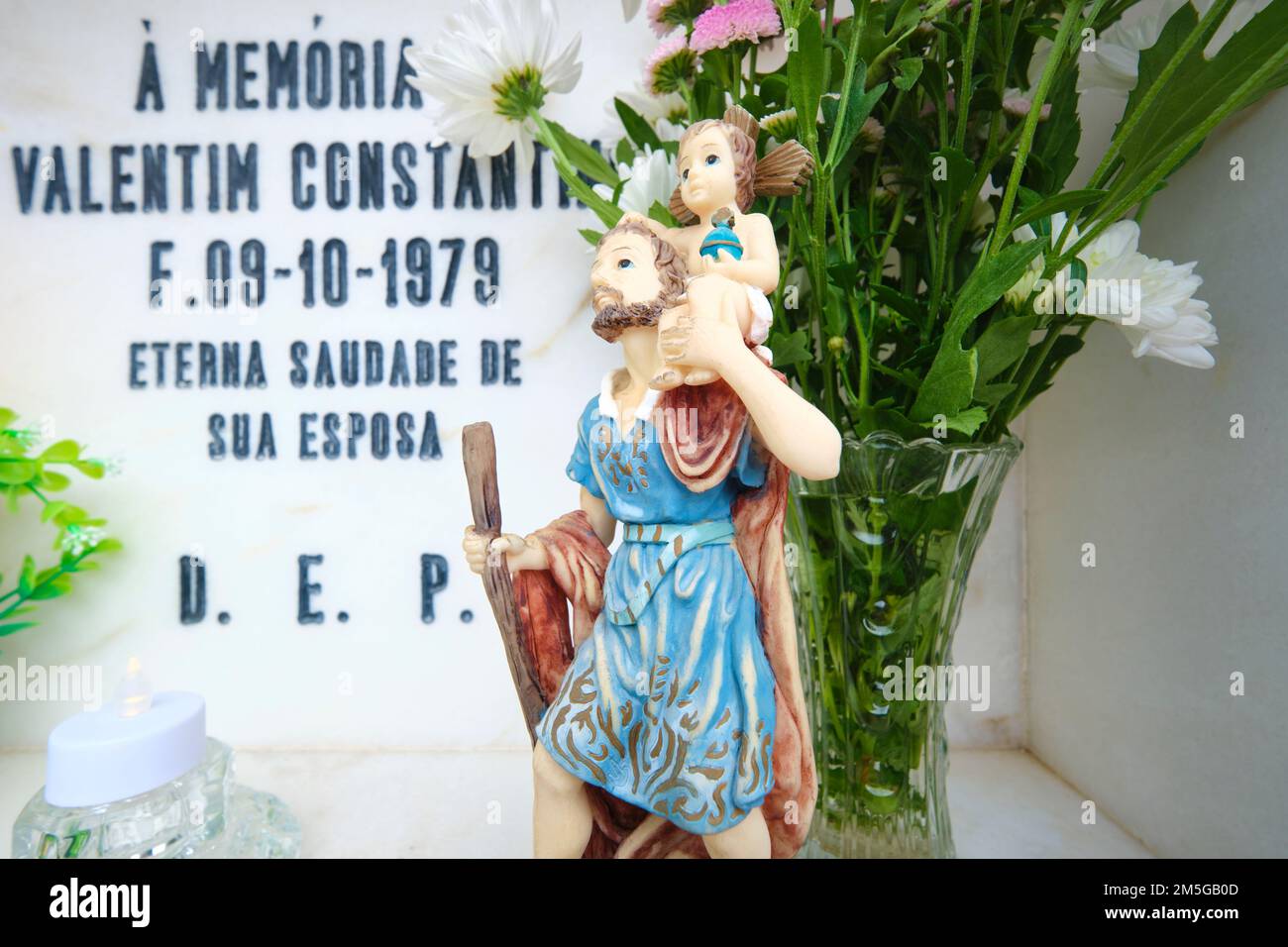 Una scultura di Gesù, icona, reliquia, che decorano una tomba in un cimitero cattolico e cristiano. Nella città di Alcoutim, nella zona di Algarve del Portogallo, occidentale Foto Stock