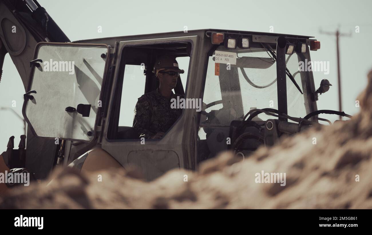 NEGLI STATI UNITI Marinaio con 29 Palms distaccati, Naval Mobile Construction Battalion 4 gestisce una terna CAT 420 al Marine Corps Air Ground Combat Center, Twentynine Palms, California, 16 marzo 2022. La nuova struttura fornirà un'altra opzione per i membri del servizio nell'ambito dell'elemento di formazione per trovare una soluzione alle sollecitazioni degli esercizi di formazione a livello di servizio. Foto Stock