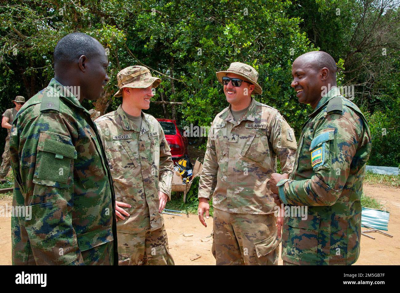 Un paio di soldati della Wahoo-base 623rd Engineer Company dell'esercito del Nebraska condivide battute con un paio di soldati della forza di difesa del Ruanda durante una pausa mentre costruisce una torre di guardia durante un esercizio in Ruanda. I soldati stavano partecipando a uno sforzo di scambio tra la Guardia Nazionale dell'Esercito del Nebraska e la forza di Difesa del Ruanda come parte del programma di partenariato di Stato della Guardia Nazionale. (Foto della Guardia Nazionale aerea del Nebraska di Lt. Col. Kevin Hynes) Foto Stock