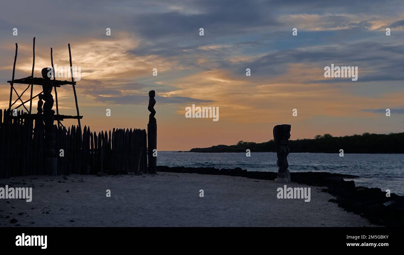 Scultura in legno sulla spiaggia di Big Island, Hawaii al tramonto. Foto Stock