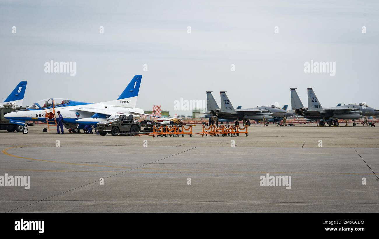 STATI UNITI Air Force F-15C Eagle assegnate al 44th Fighter Squadron, Kadena Air base, Giappone, parcheggiano presso la Japan Air Self-Defense Force Tsuiki Air base, mentre i membri del Blue Impulse di JASDF eseguono controlli pre-volo, il 17 marzo 2022. La base aerea di Tsuiki sta ospitando l'iterazione corrente del programma di trasferimento di addestramento di aeronautica che aumenta la preparazione operativa e migliora l'interoperabilità con i nostri alleati giapponesi. Foto Stock