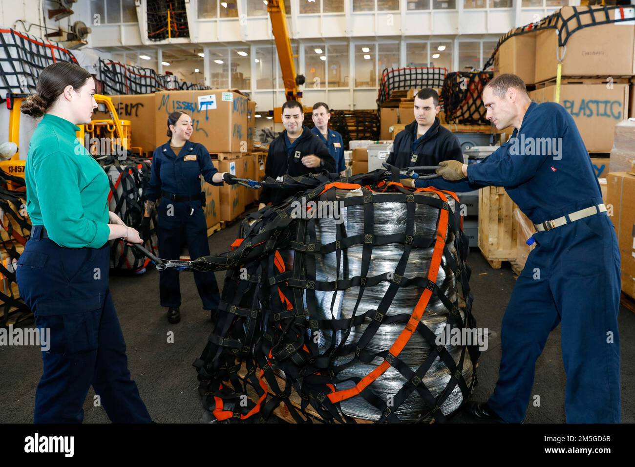 MARE DELLE FILIPPINE (17 marzo 2022) i marinai preparano il carico per uno scarico nella baia di hangar a bordo della portaerei di classe Nimitz USS Abraham Lincoln (CVN 72). Abraham Lincoln Strike Group è in fase di implementazione pianificata nell'area delle operazioni della flotta 7th degli Stati Uniti per migliorare l'interoperabilità attraverso alleanze e partnership e al tempo stesso fungere da forza di risposta pronta a sostegno di una regione indomPacifico libera e aperta. Foto Stock
