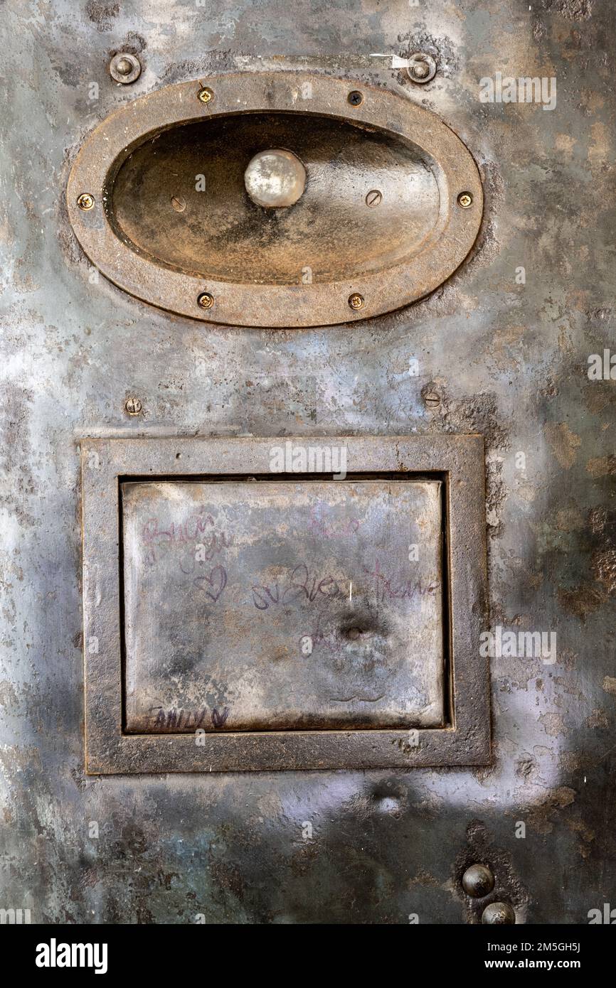 Spioncino e portello in un'antica porta della cella della prigione Foto Stock