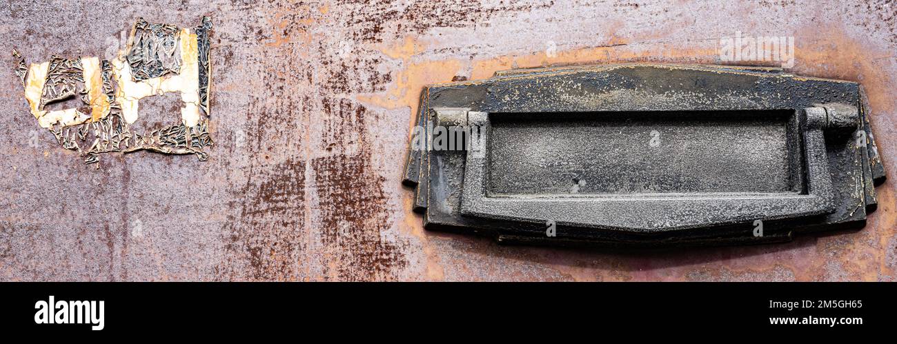 Immagine di una cassetta delle lettere vintage in una porta anteriore in acciaio arrugginito Foto Stock