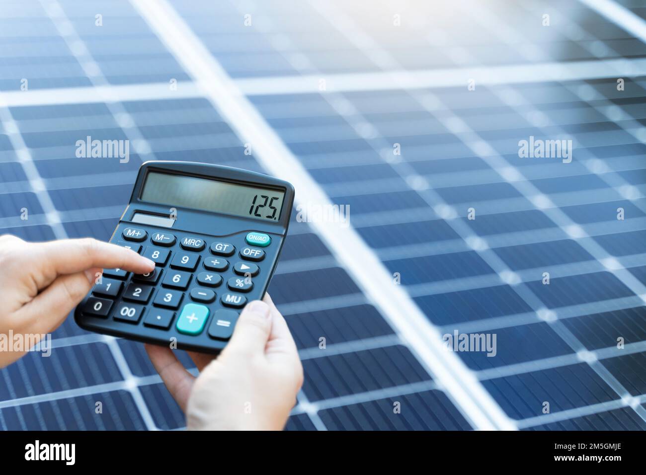 Concetto di risparmio energetico con pannelli solari e calcolatrice Foto Stock