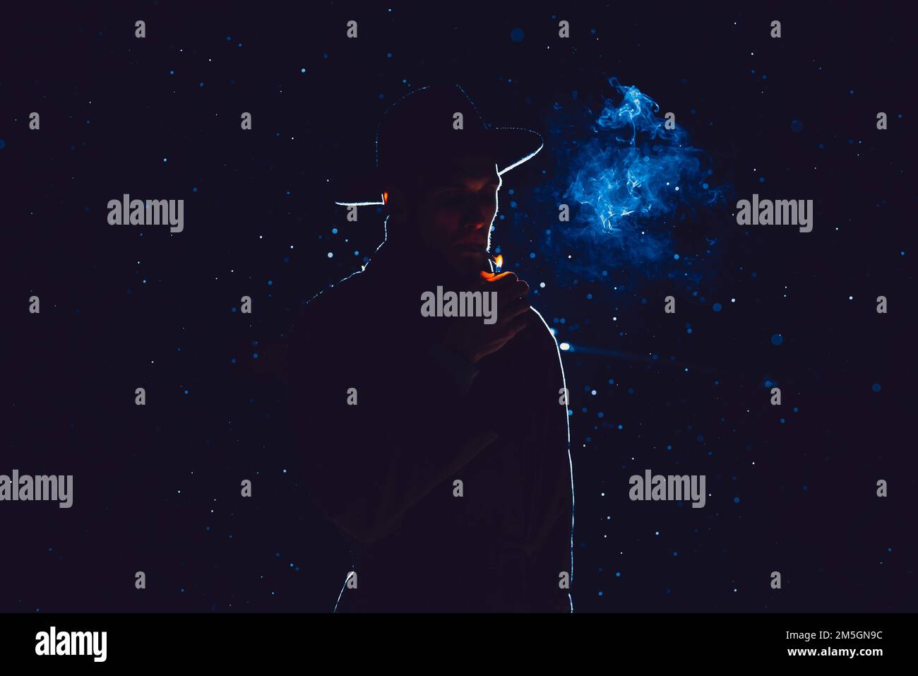 silhouette di un detective maschile in un cappello e impermeabile fumare di notte sotto la pioggia Foto Stock