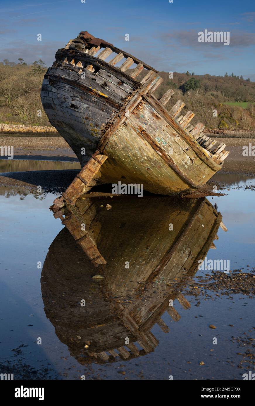 Abbandonato legno costruito barca da pesca su una spiaggia gallese Foto Stock